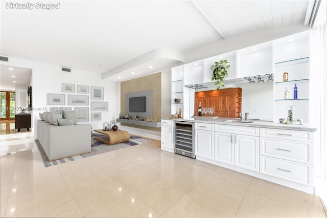 living room featuring light tile patterned flooring, beverage cooler, and sink