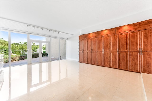 unfurnished room featuring expansive windows, french doors, rail lighting, and light tile patterned floors