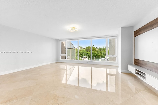 interior space featuring a water view and a textured ceiling