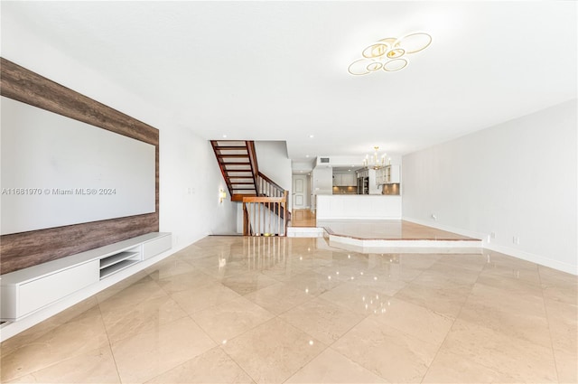 unfurnished living room featuring an inviting chandelier