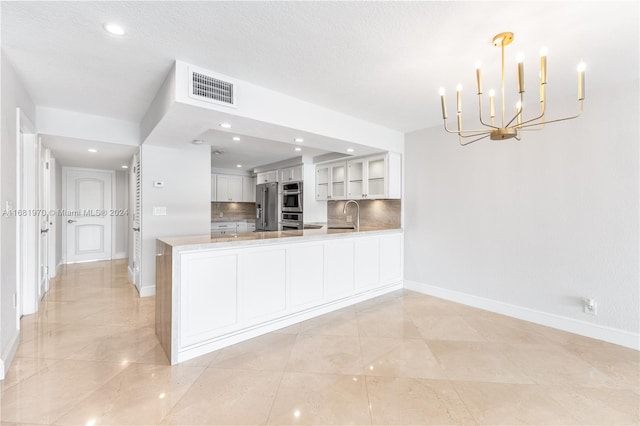 kitchen featuring sink, white cabinetry, kitchen peninsula, and tasteful backsplash