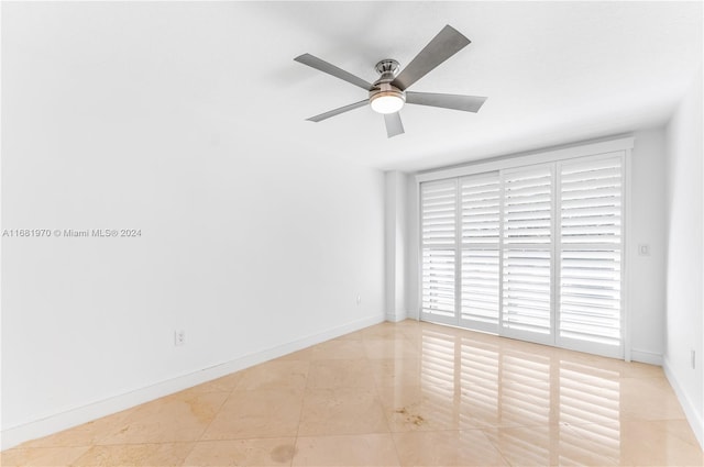 spare room featuring ceiling fan and light tile patterned floors