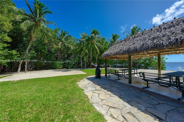 view of property's community with a gazebo, a water view, volleyball court, and a lawn