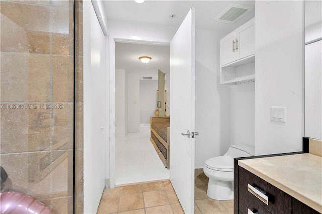 bathroom with toilet, vanity, and a shower with door