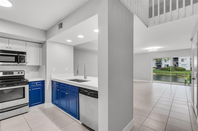 2394 NW 97th Way Unit 2394, Pembroke Pines, FL 33024 - kitchen featuring appliances with stainless steel finishes, blue cabinetry, light tile patterned floors, light countertops, and recessed lighting