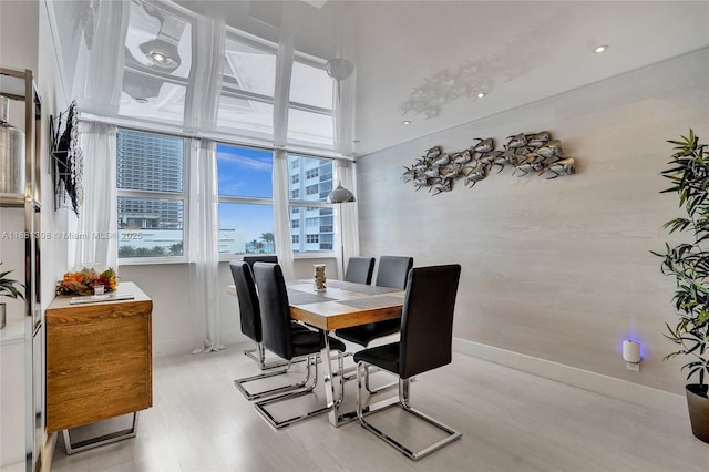 dining area featuring light wood-type flooring and baseboards