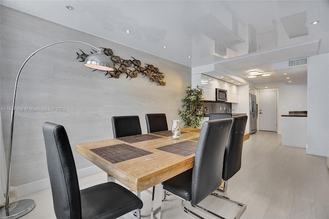 dining space featuring visible vents and light wood finished floors