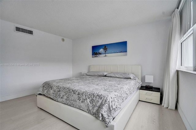 bedroom featuring a textured ceiling and light wood-type flooring