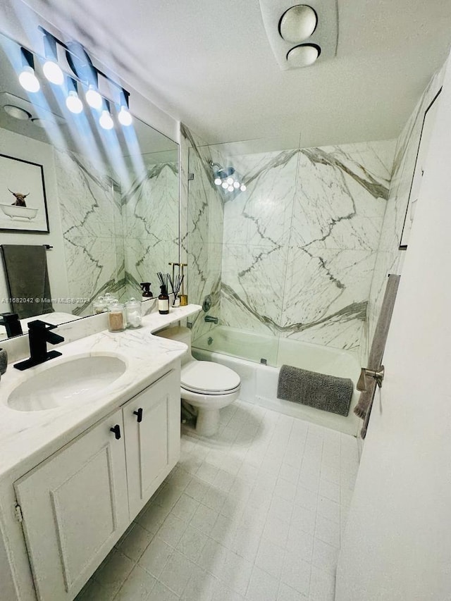 full bathroom featuring tiled shower / bath, vanity, and toilet