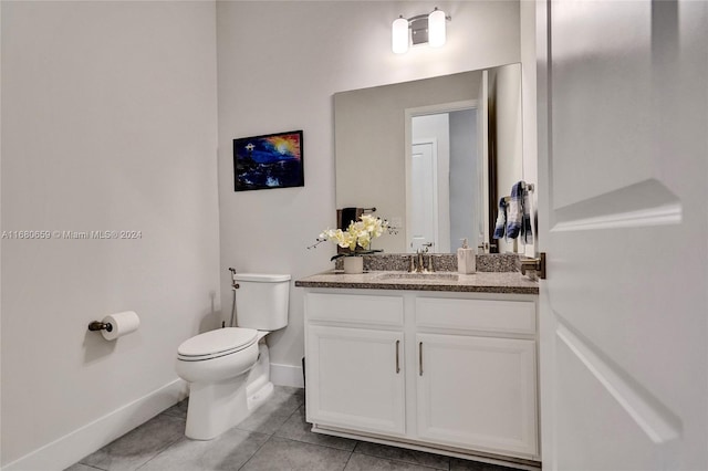 bathroom with tile patterned flooring, vanity, and toilet