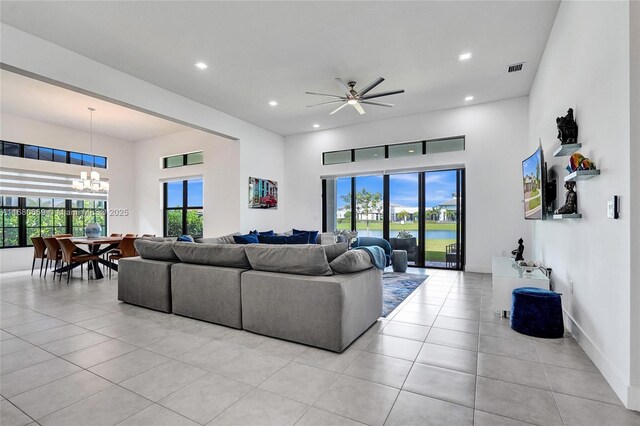 tiled living room with ceiling fan with notable chandelier and sink