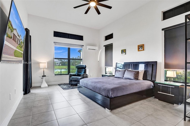 bedroom featuring an AC wall unit, baseboards, and light tile patterned floors