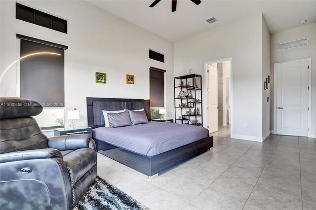 tiled bedroom featuring an AC wall unit, ceiling fan, and a high ceiling