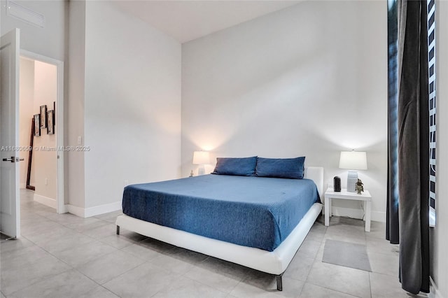 bedroom with baseboards and light tile patterned floors