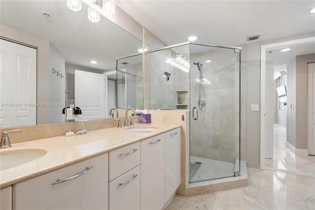 bathroom with a shower with door and vanity