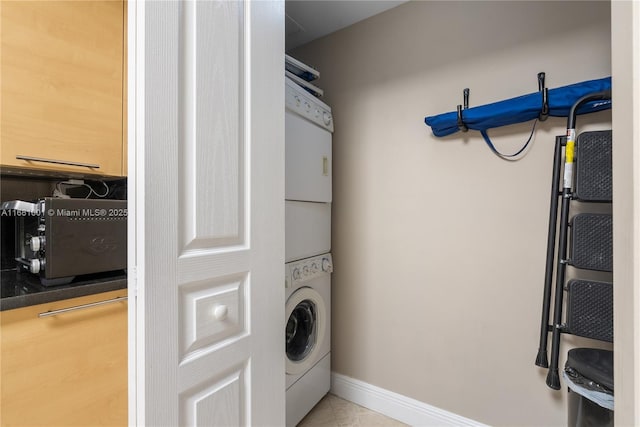 clothes washing area featuring light tile patterned flooring and stacked washer / drying machine