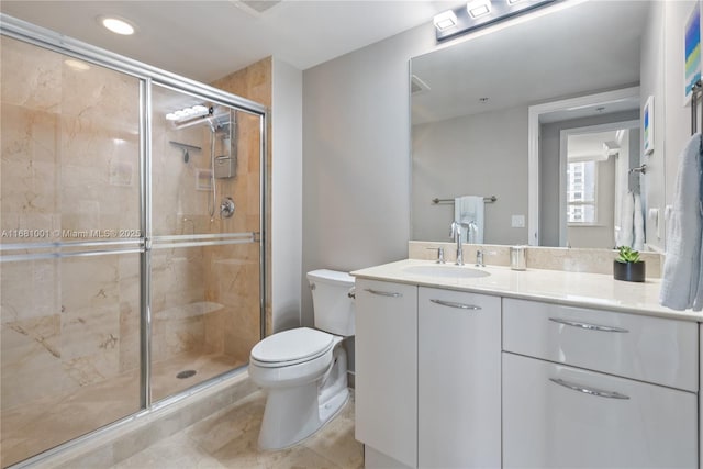 bathroom with vanity, a shower with shower door, tile patterned floors, and toilet