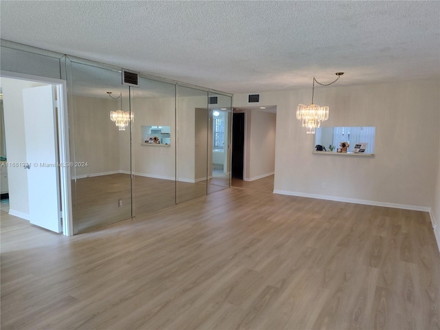 empty room with hardwood / wood-style floors and a textured ceiling