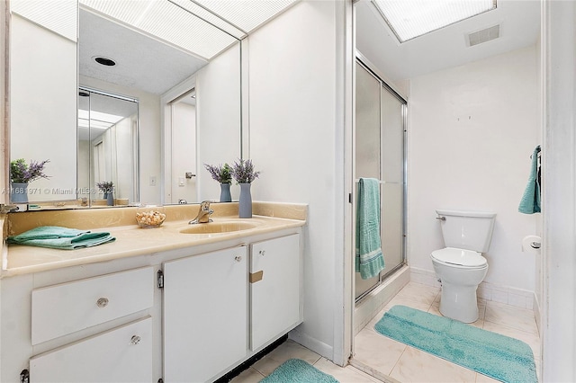 bathroom featuring tile patterned flooring, vanity, an enclosed shower, and toilet