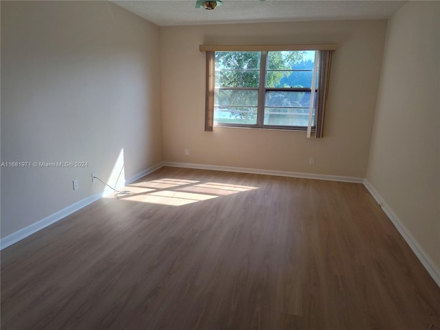 empty room with a textured ceiling and hardwood / wood-style flooring