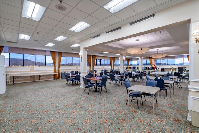 carpeted dining space with a paneled ceiling and a tray ceiling