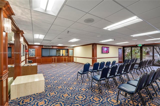 interior space with carpet, a paneled ceiling, and ornamental molding