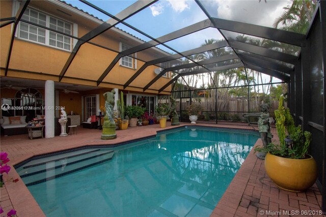 view of swimming pool with a patio and glass enclosure