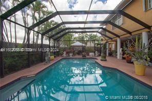 view of pool with a patio and glass enclosure