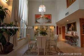 dining area featuring a notable chandelier and a high ceiling