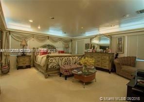 carpeted bedroom featuring crown molding and a tray ceiling