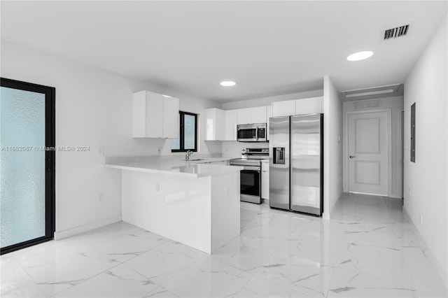 kitchen featuring white cabinetry, stainless steel appliances, sink, and kitchen peninsula