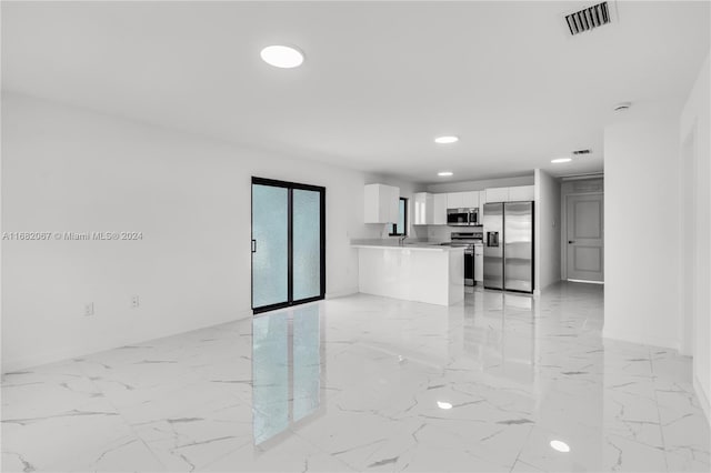 kitchen with white cabinetry, stainless steel appliances, sink, and kitchen peninsula