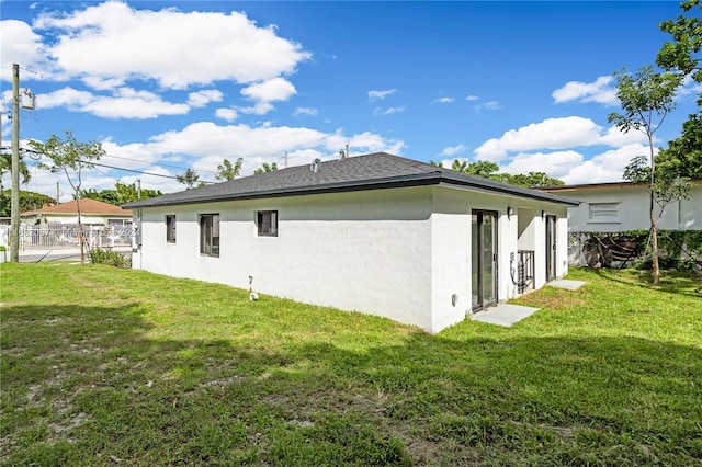 rear view of property featuring a lawn