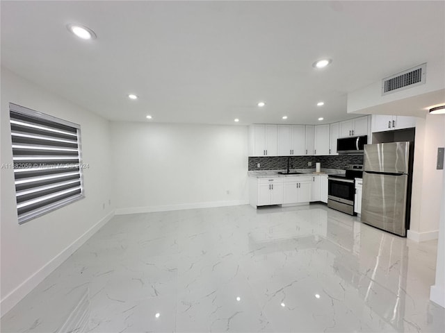 kitchen with appliances with stainless steel finishes, decorative backsplash, white cabinetry, and sink