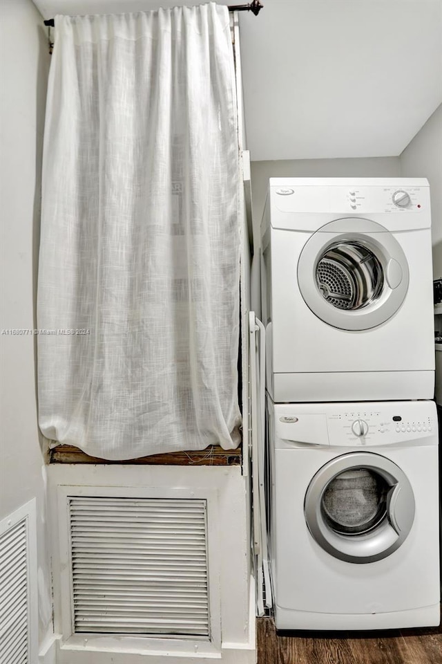 washroom with stacked washer / dryer and dark hardwood / wood-style flooring