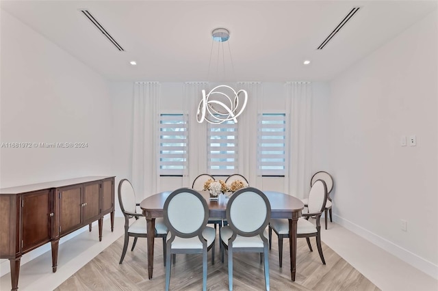 7720 SW 130th St, Pinecrest, FL 33156 - dining space with baseboards, an inviting chandelier, visible vents, and light wood-style flooring