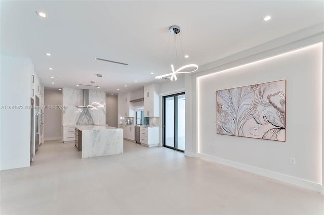 kitchen featuring white cabinets, stainless steel dishwasher, sink, pendant lighting, and a center island