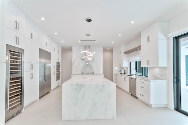 kitchen featuring wine cooler, appliances with stainless steel finishes, white cabinetry, and decorative light fixtures