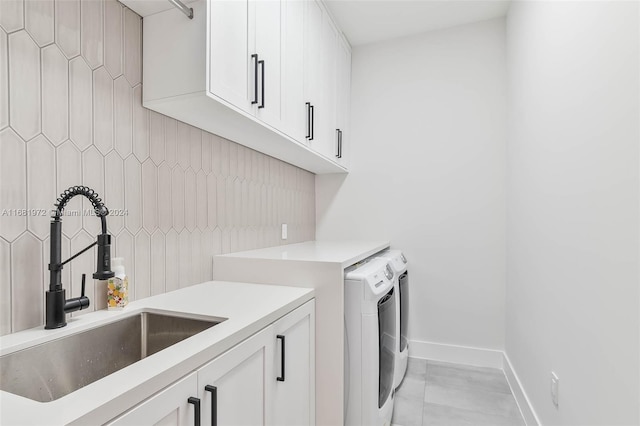 washroom featuring independent washer and dryer, cabinets, and sink