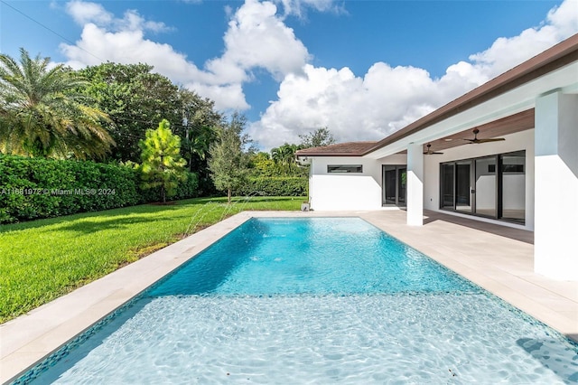 view of swimming pool with a patio area, a lawn, and ceiling fan