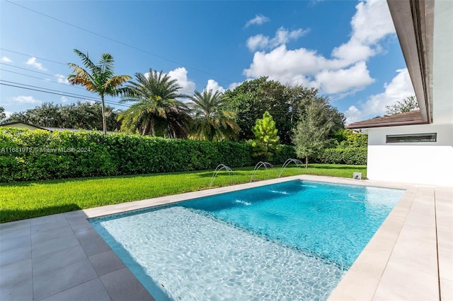 view of swimming pool featuring pool water feature, a patio area, and a lawn