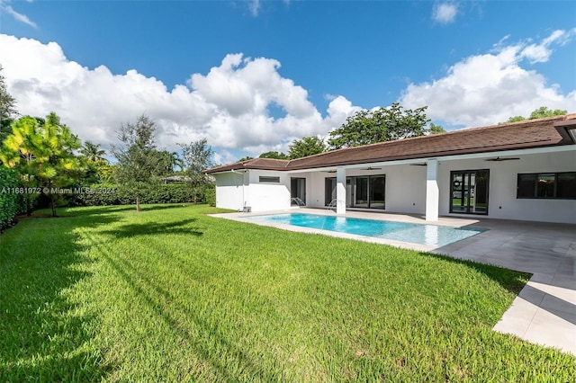 rear view of house featuring a fenced in pool, a patio area, a yard, and ceiling fan