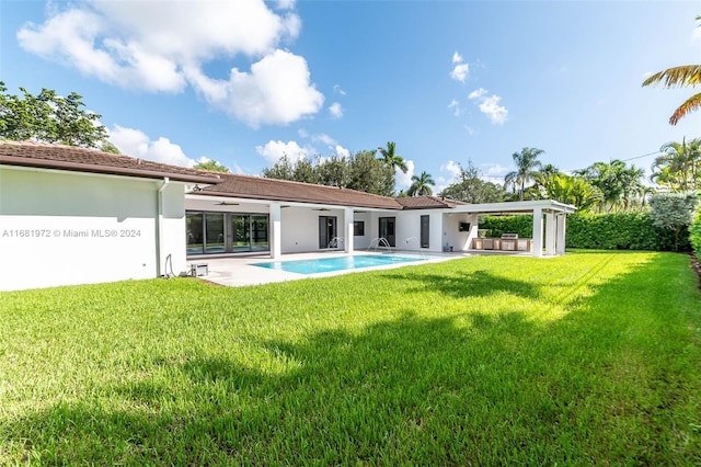 7720 SW 130th St, Pinecrest, FL 33156 - back of property with stucco siding, a patio area, an outdoor pool, and a yard
