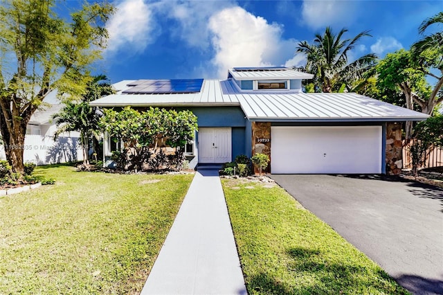 view of front facade featuring solar panels, a garage, and a front lawn