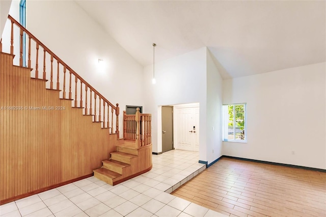 entrance foyer with light hardwood / wood-style floors and high vaulted ceiling