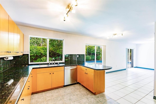 kitchen featuring dishwasher, a healthy amount of sunlight, kitchen peninsula, and backsplash