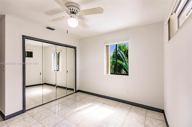 unfurnished bedroom with ceiling fan and a closet