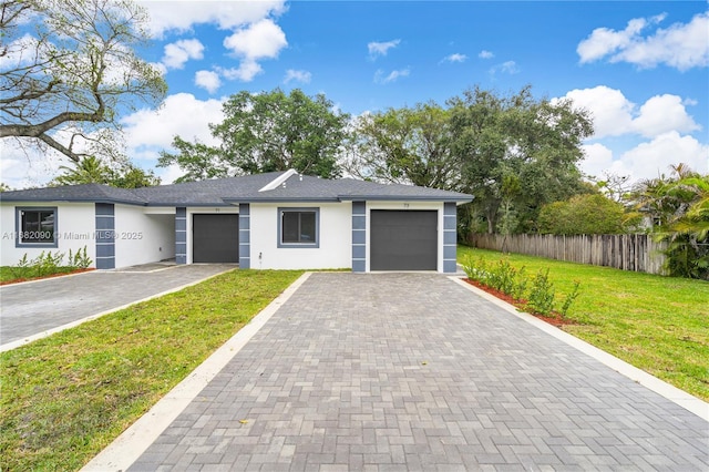 single story home with a garage and a front lawn