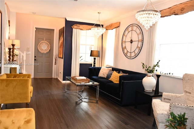 living room with dark hardwood / wood-style floors, ornamental molding, and an inviting chandelier