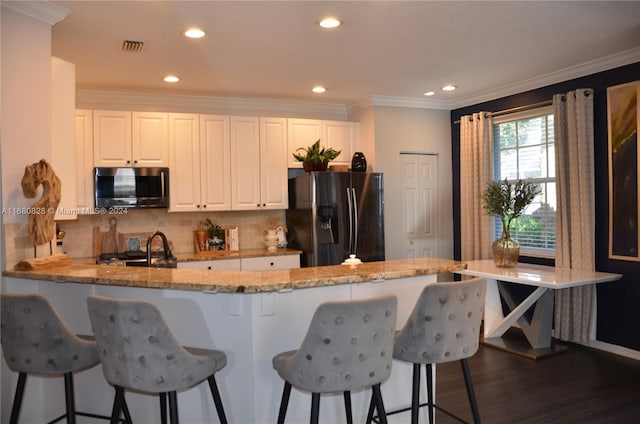 kitchen with dark hardwood / wood-style floors, light stone countertops, white cabinetry, and appliances with stainless steel finishes